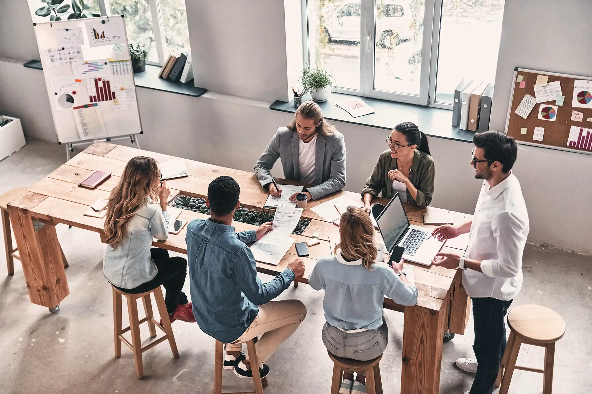 A top-down view of a team of young professionals discussing a project together.